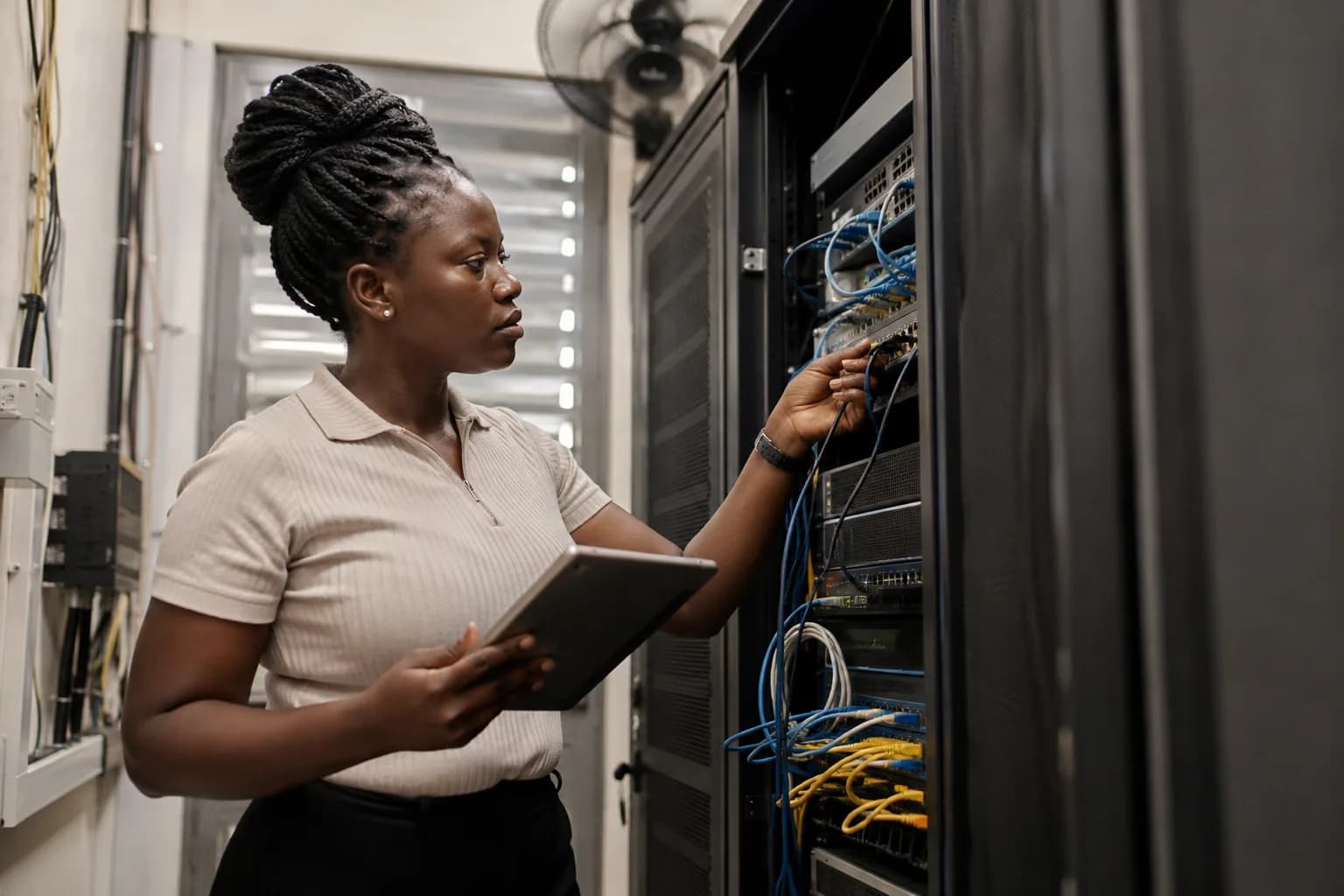 A technology operations engineer inspecting network equipment