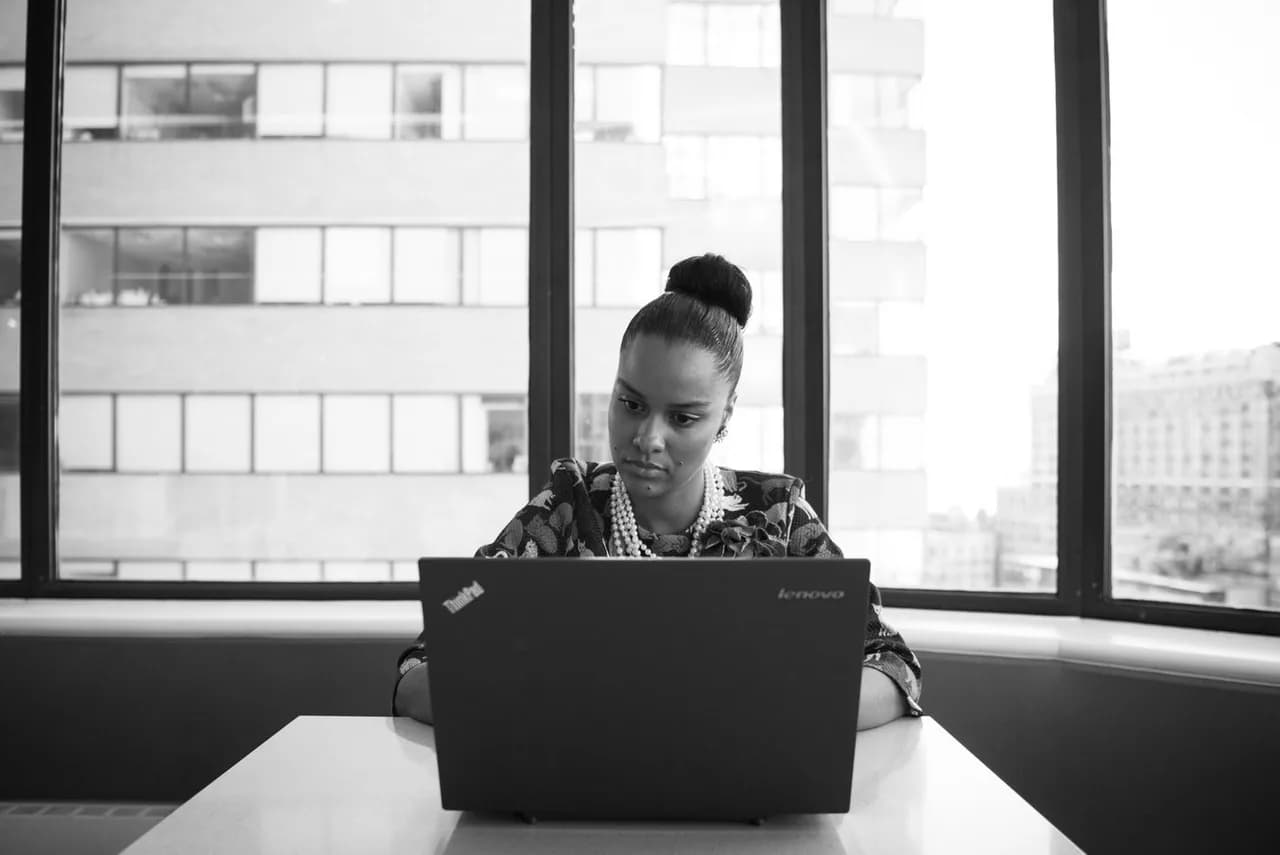 A technology professional focusing on her work at a laptop