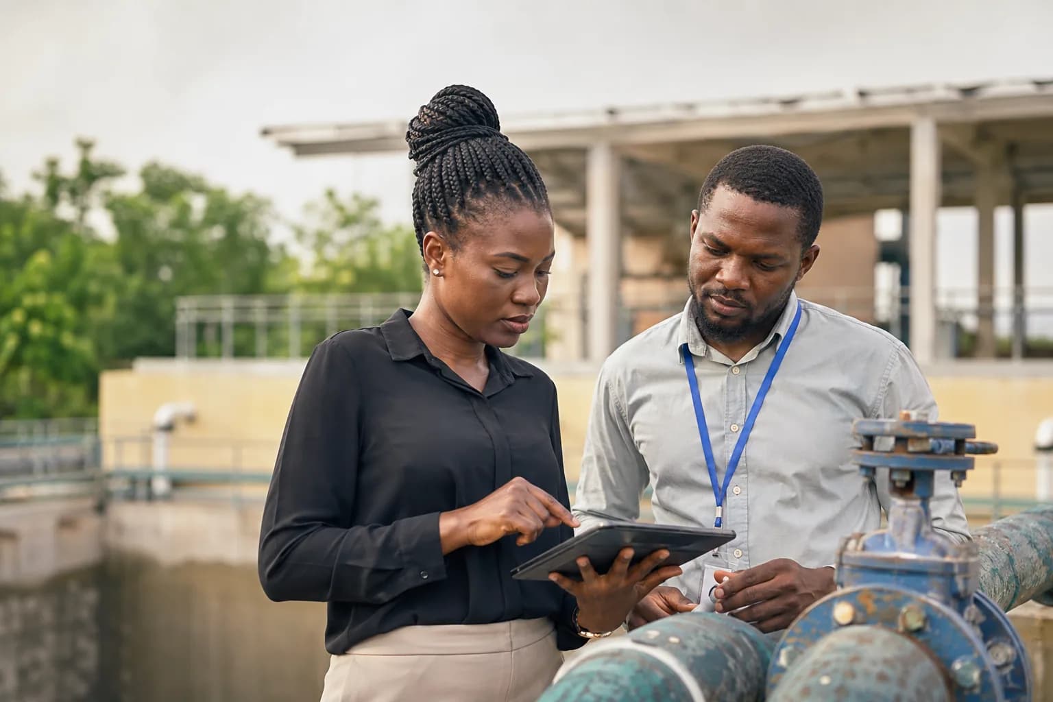 Programme officers reviewing a community water infrastructure project