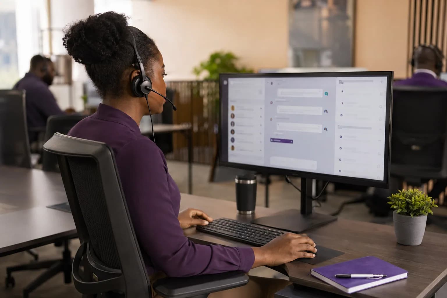 A customer support specialist reviewing conversations and handoffs at her workstation
